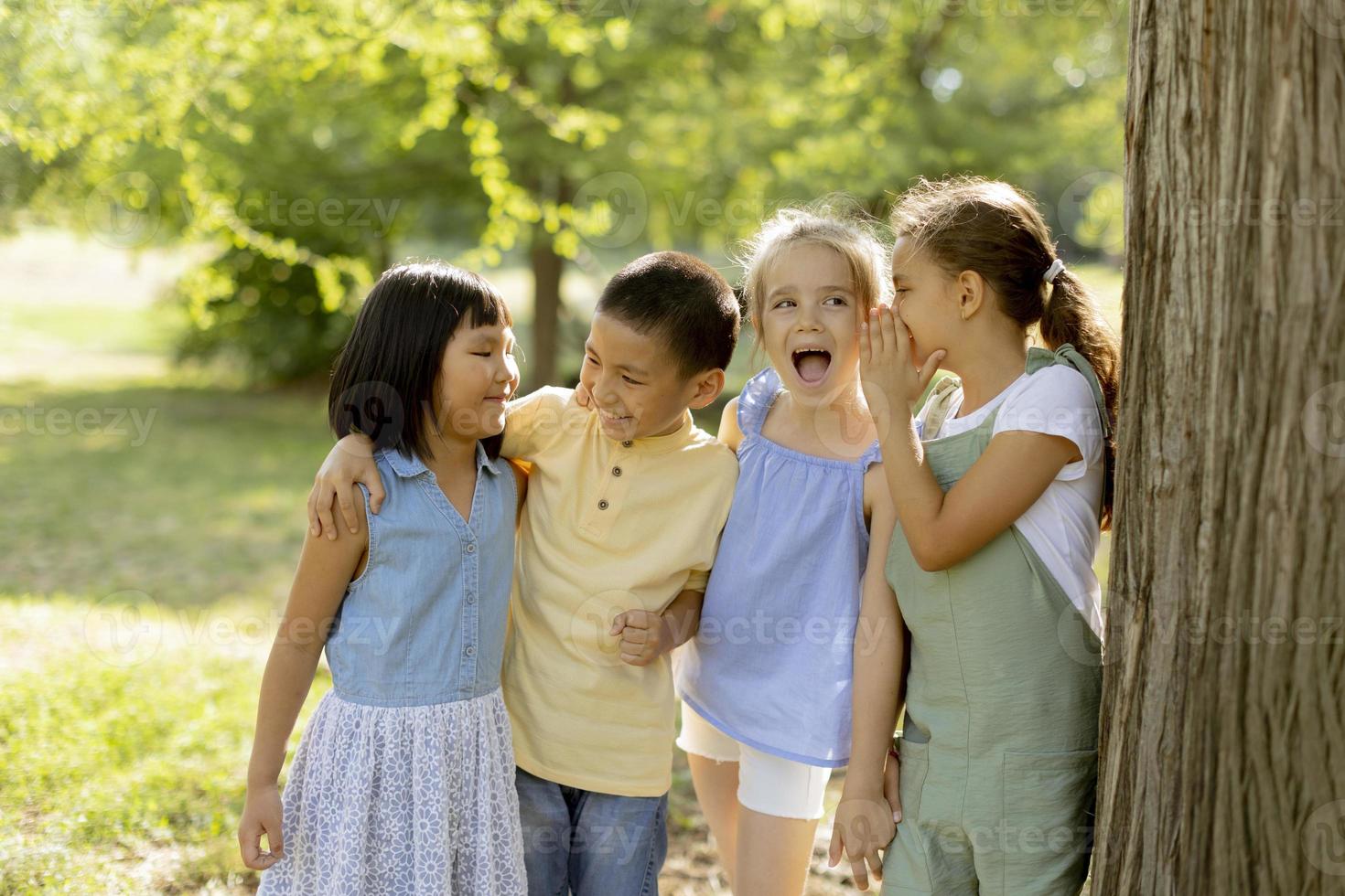 gruppo di asiatico e caucasico bambini avendo divertimento nel il parco foto