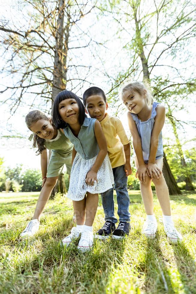 gruppo di asiatico e caucasico bambini avendo divertimento nel il parco foto