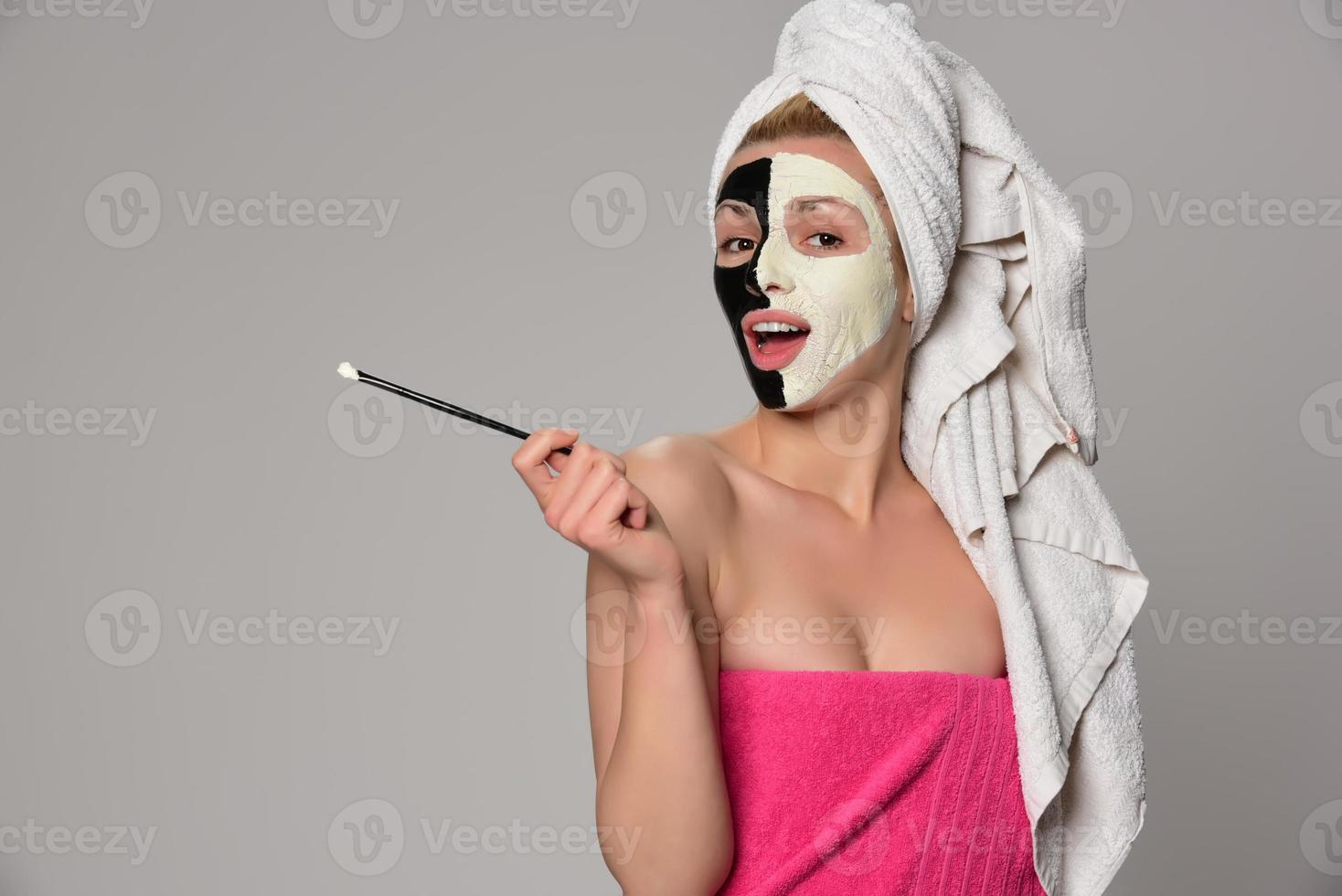 bellissimo femmina modello con nero e bianca facciale cosmetico maschera foto