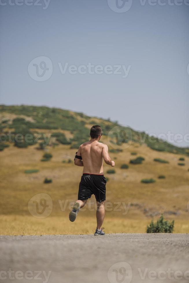 sportivo uomo corridore in esecuzione su montagna altopiano nel estate foto