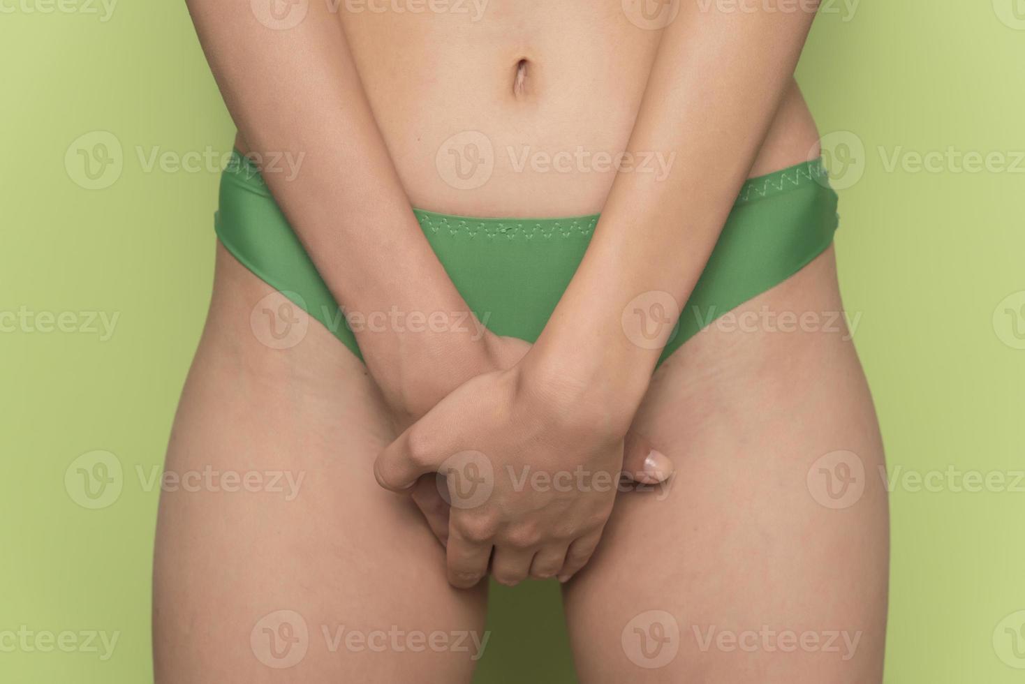 donna con mani Tenere sua forcella nel dolore. Vescica urinaria dolore. foto