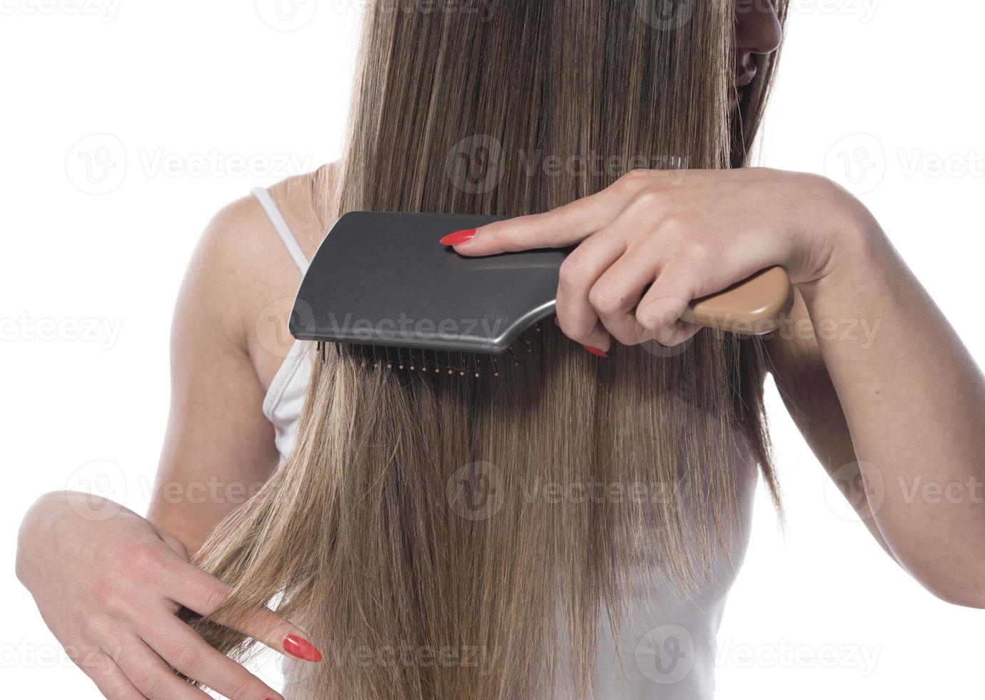 giovane bellissimo donna pettinatura sua capelli nel il mattina. capelli cura concetto. foto