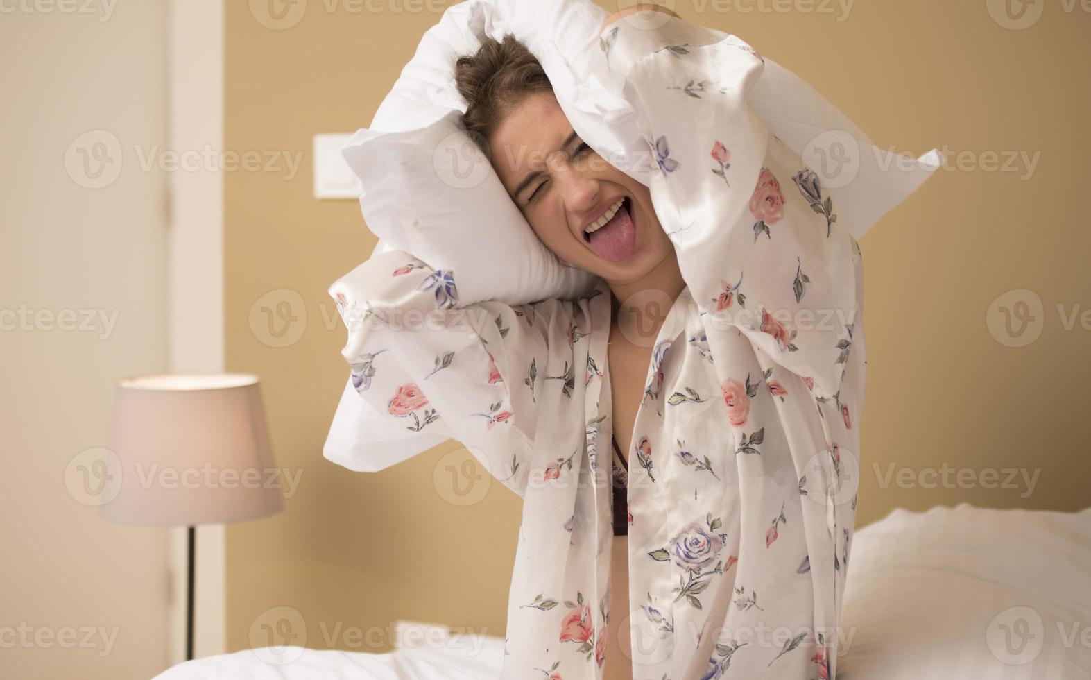 giovane donna abbracciare cuscino su confortevole letto con di seta biancheria foto