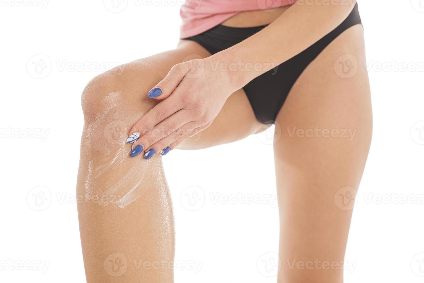 corpo cura. sconosciuto donna l'applicazione crema su gambe. femmina l'applicazione anti cellulite crema foto