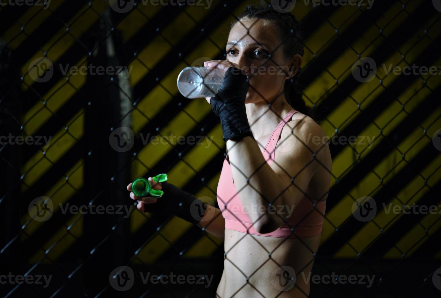 femmina combattente potabile acqua e riposo dopo il addestramento. foto