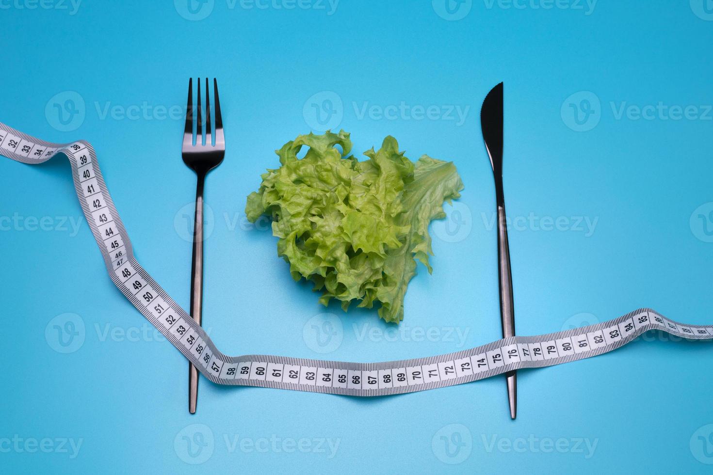 insalata e misurazione nastro su il blu sfondo. il concetto di dieta. foto