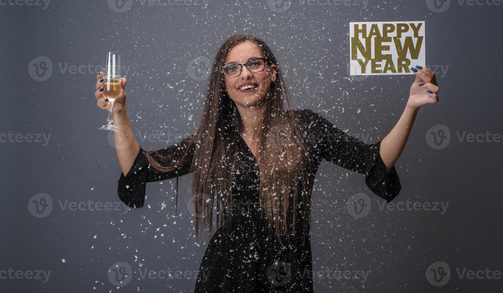 bellissimo donna festeggiare nuovo anno con coriandoli e Champagne Tenere cartello. isolato foto