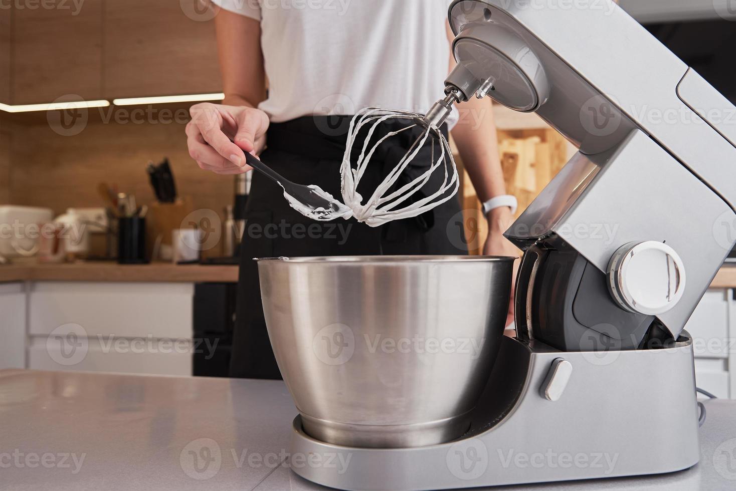 donna utilizzando cibo processore per cucinando nel cucina foto