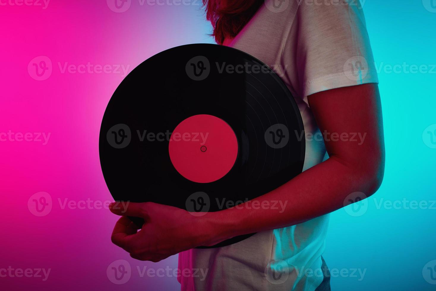 donna hold retrò vinile disco con neon leggero foto