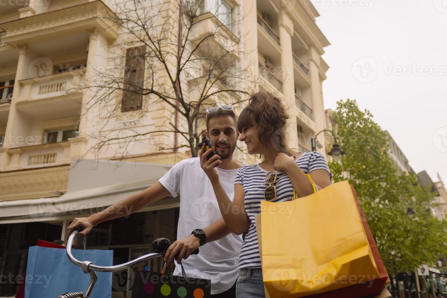 ritratto di allegro caucasico giovane coppia uomo e donna Tenere molti carta borse dopo shopping mentre a piedi e parlando su strada. contento famiglia coppia con pacchi all'aperto. acquisto concetto foto