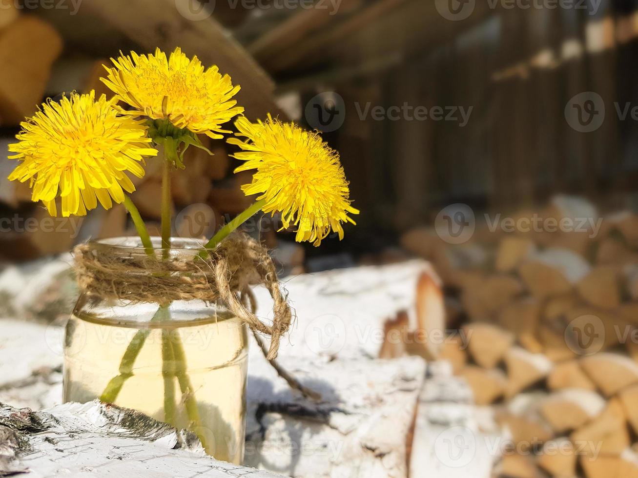 catasta di legna di betulla legna da ardere. tre giallo denti di leone nel un' bicchiere barattolo. preparazione di legna per il forno. foto