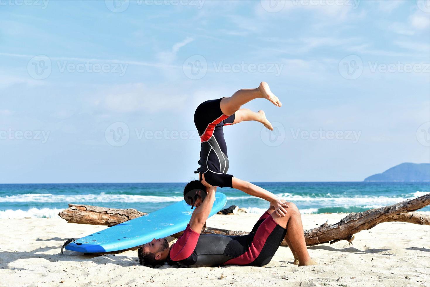 in forma sportivo coppia praticante acro yoga con compagno insieme. in forma sportivo coppia praticante acrobatico yoga insieme su il spiaggia foto