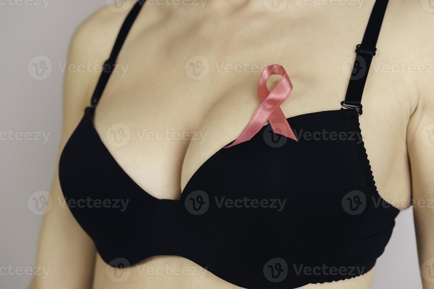 Salute cura, medicina e Seno cancro consapevolezza concetto. giovane donna nel reggiseno con rosa nastro simbolo foto