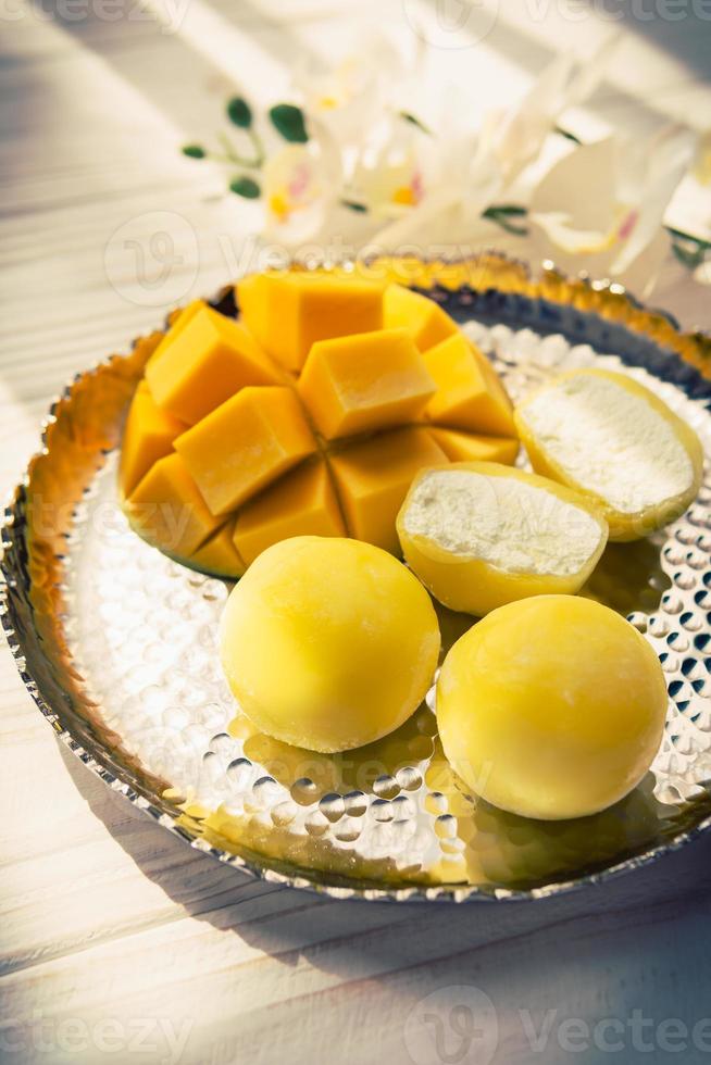 gustoso dolce mochi con Mango frutta su di legno sfondo foto