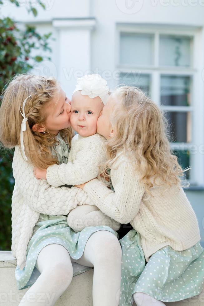 3 poco ragazze con leggero capelli siamo abbracciare. amore di sorelle foto