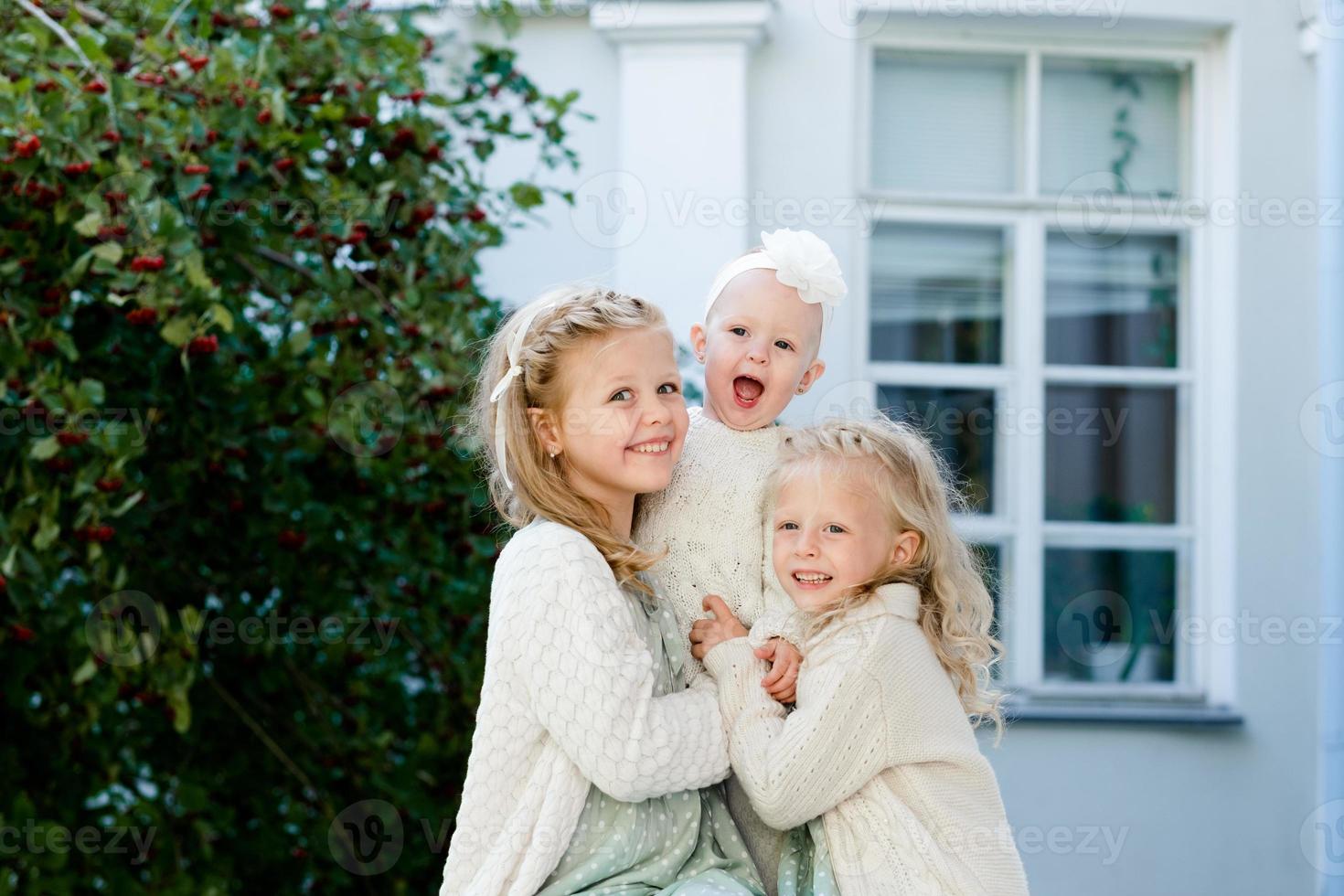 3 poco ragazze con leggero capelli siamo abbracciare. amore di sorelle foto