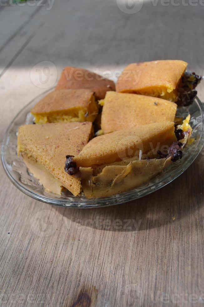 terang bulan cibo fatto a partire dal Farina e ripieno con nero appiccicoso riso originario a partire dal Indonesia. con piatti e di legno sfondo. foto