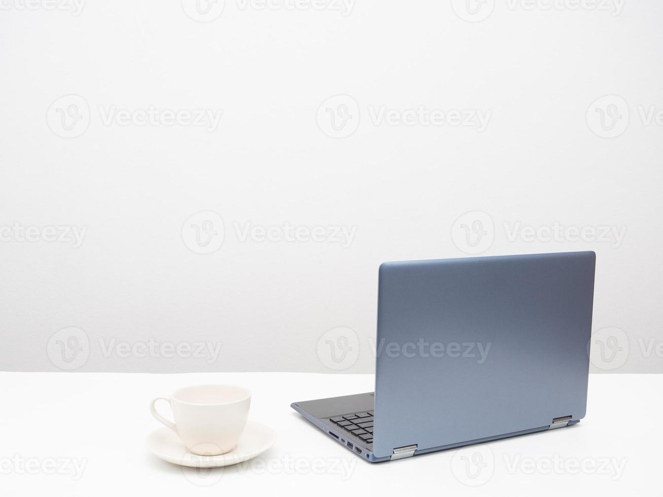 il computer portatile con caffè tazza su il tavolo copia spazio bianca sfondo foto