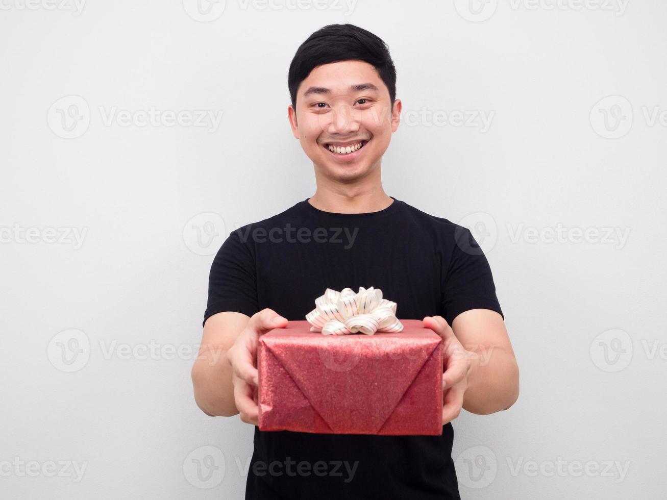 asiatico uomo sorridente sensazione contento dando regalo scatola per voi foto