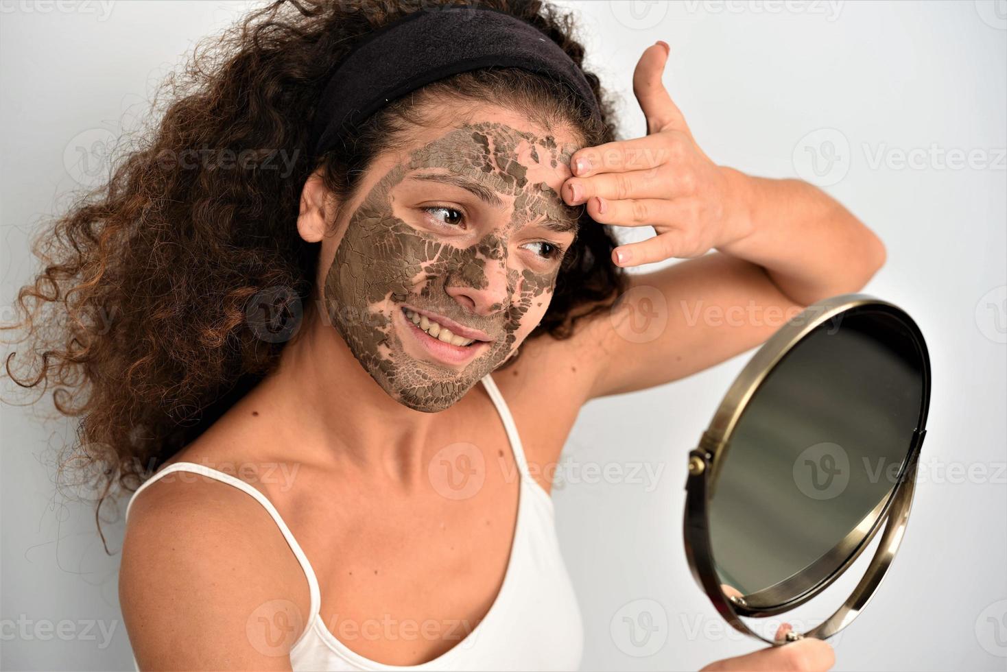 bellissimo donna avendo argilla facciale maschera foto