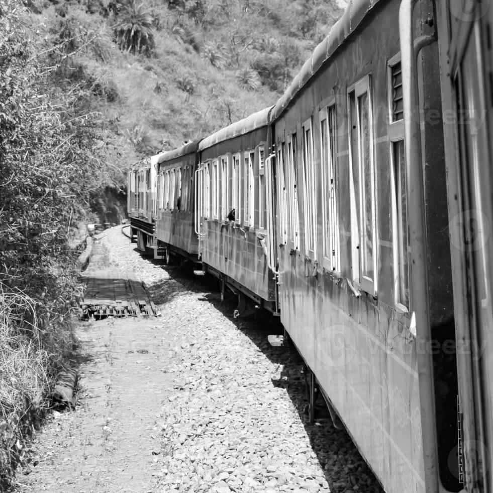 giocattolo treno in movimento su montagna pendenza, bellissimo Visualizza, uno lato montagna, uno lato valle in movimento su ferrovia per il collina, tra verde naturale foresta.giocattolo treno a partire dal calca per shimla nel nero indiano e bianca foto