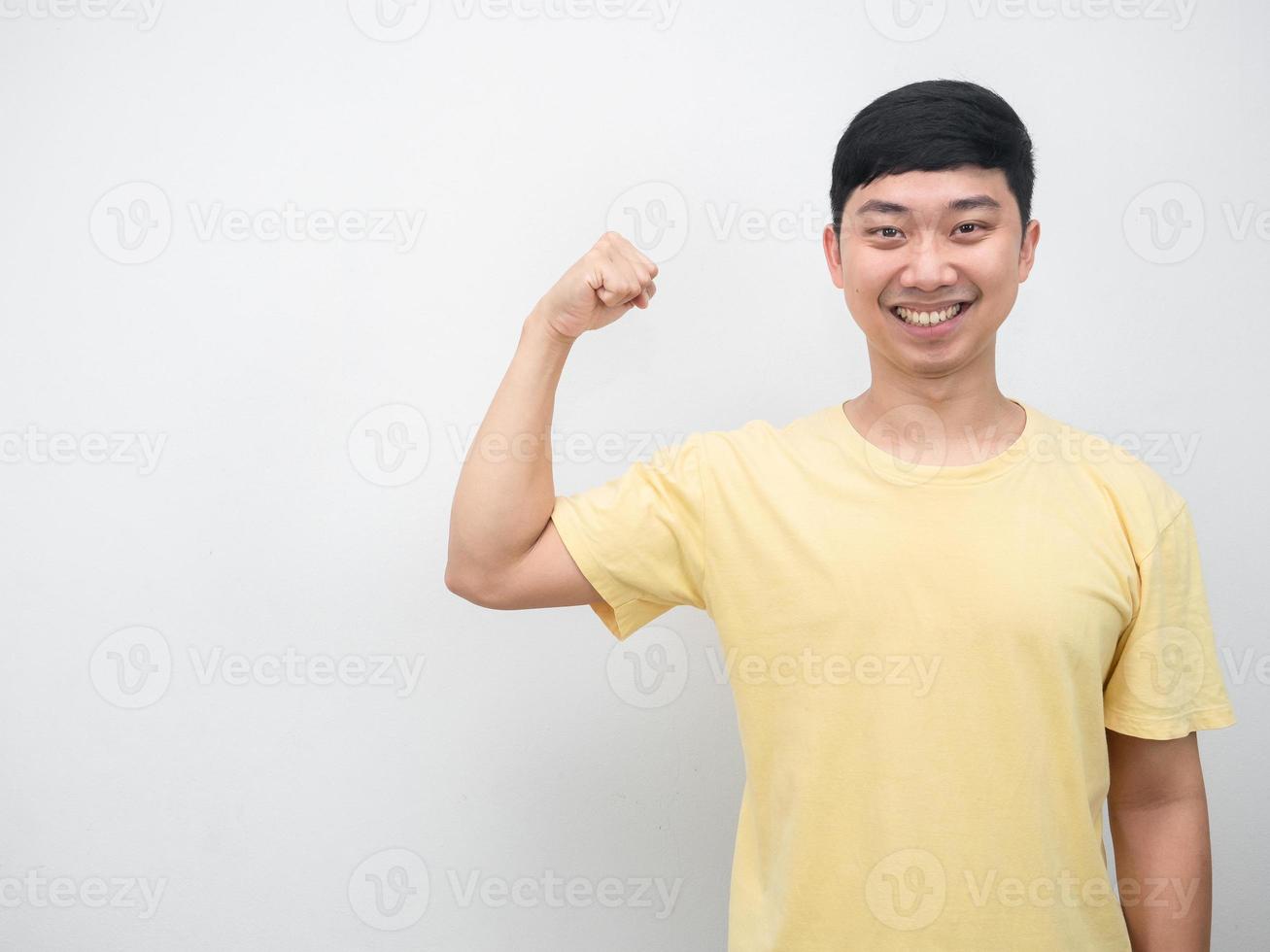 asiatico uomo giallo camicia sorridente mostrare muscolo copia spazio foto