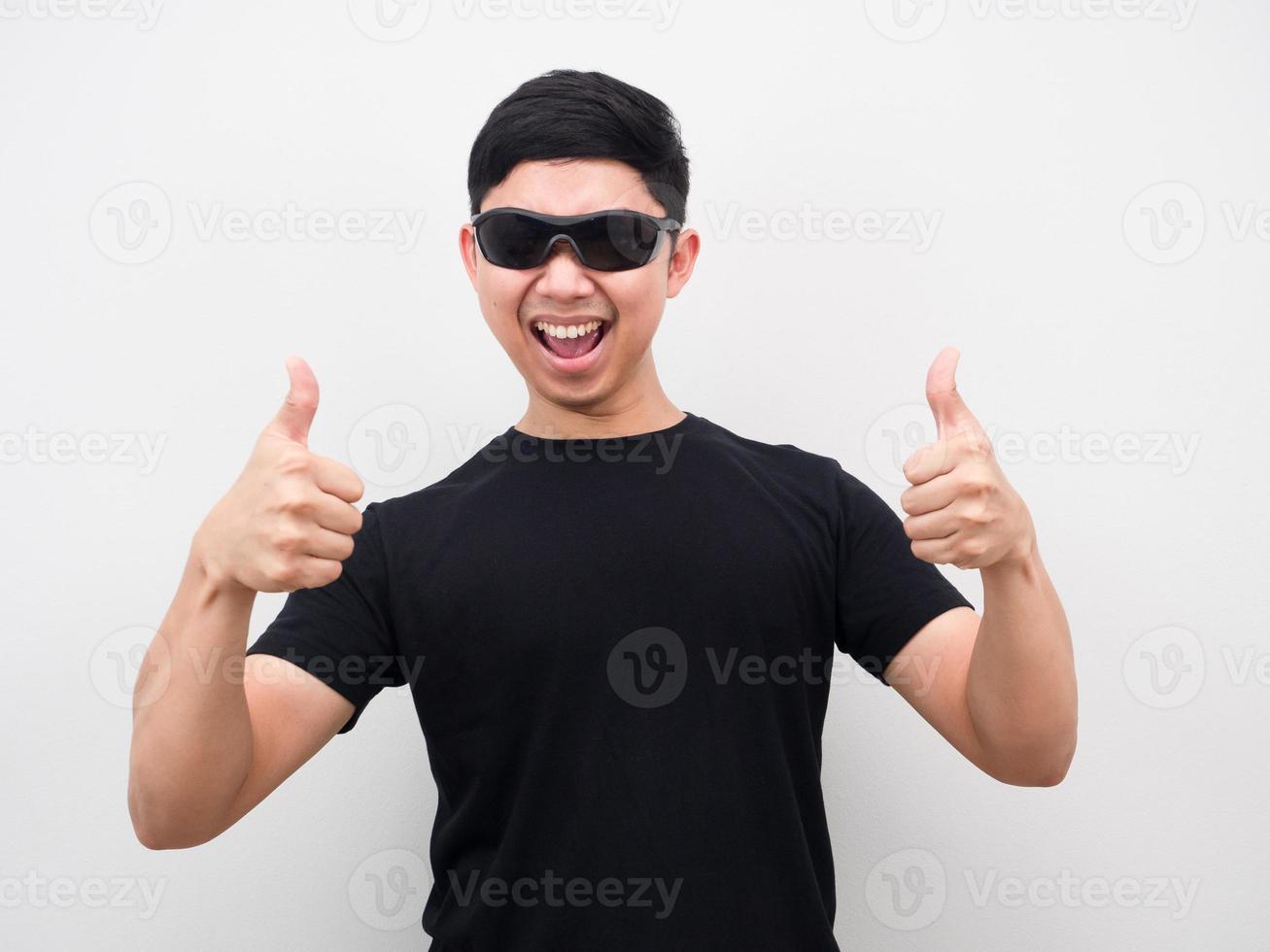 uomo indossare occhiali da sole gesto pollice su bianca sfondo foto