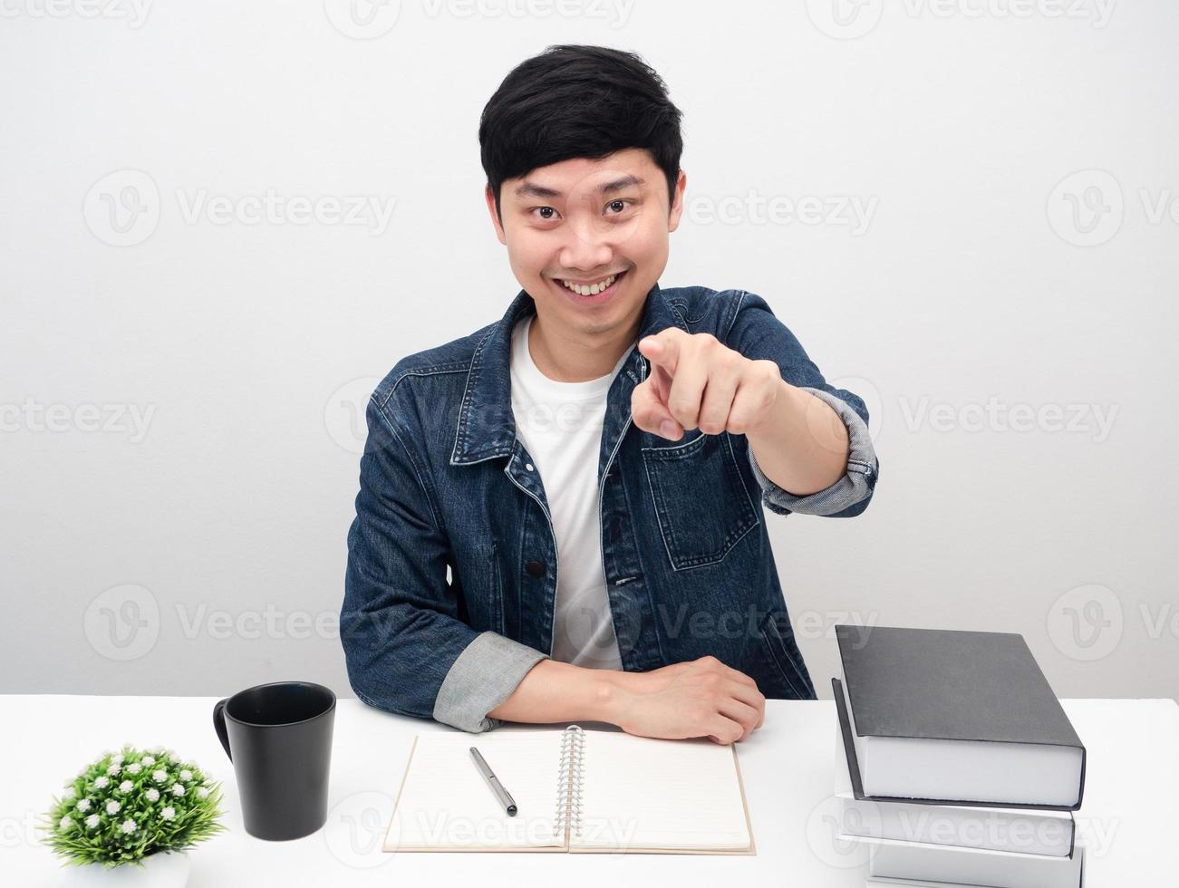 allegro uomo sedersi a tavolo con libri e caffè tazza punto dito a voi foto