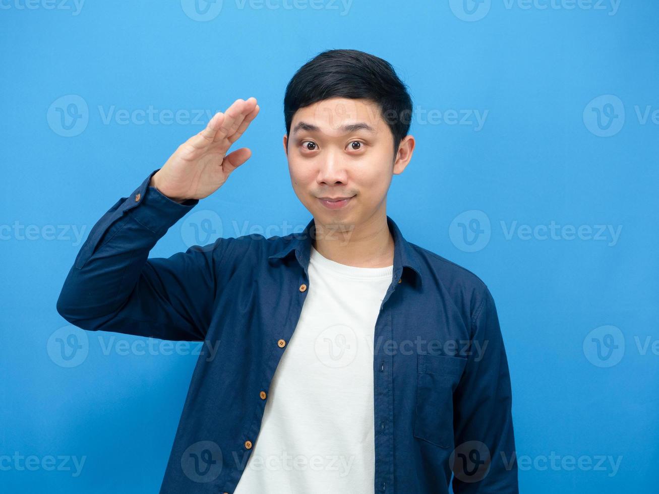 asiatico uomo gesto rispetto mano piace soldato allegro blu sfondo foto