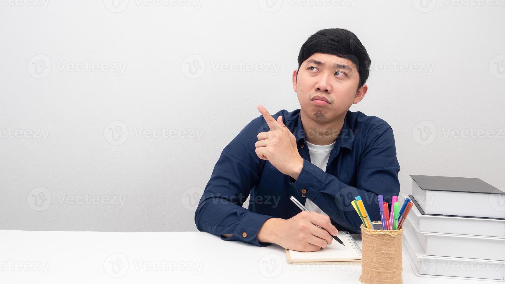 uomo seduta Lavorando a il scrivania sensazione annoiato punto dito a copia spazio foto