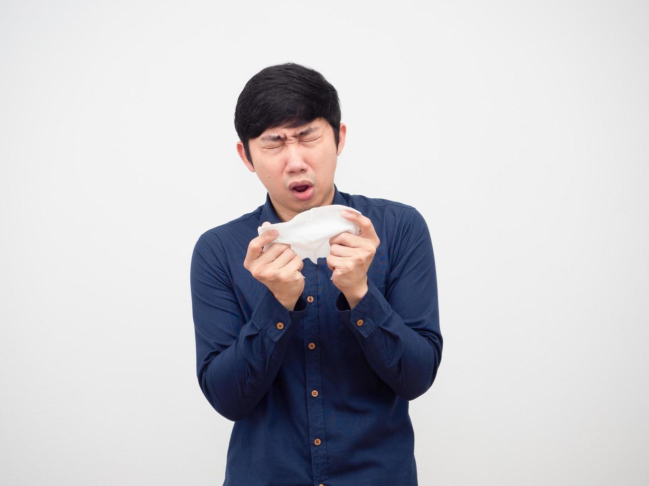 asiatico uomo malato e starnuto a fazzoletto di carta carta nel il suo mano bianca sfondo, malato concetto foto