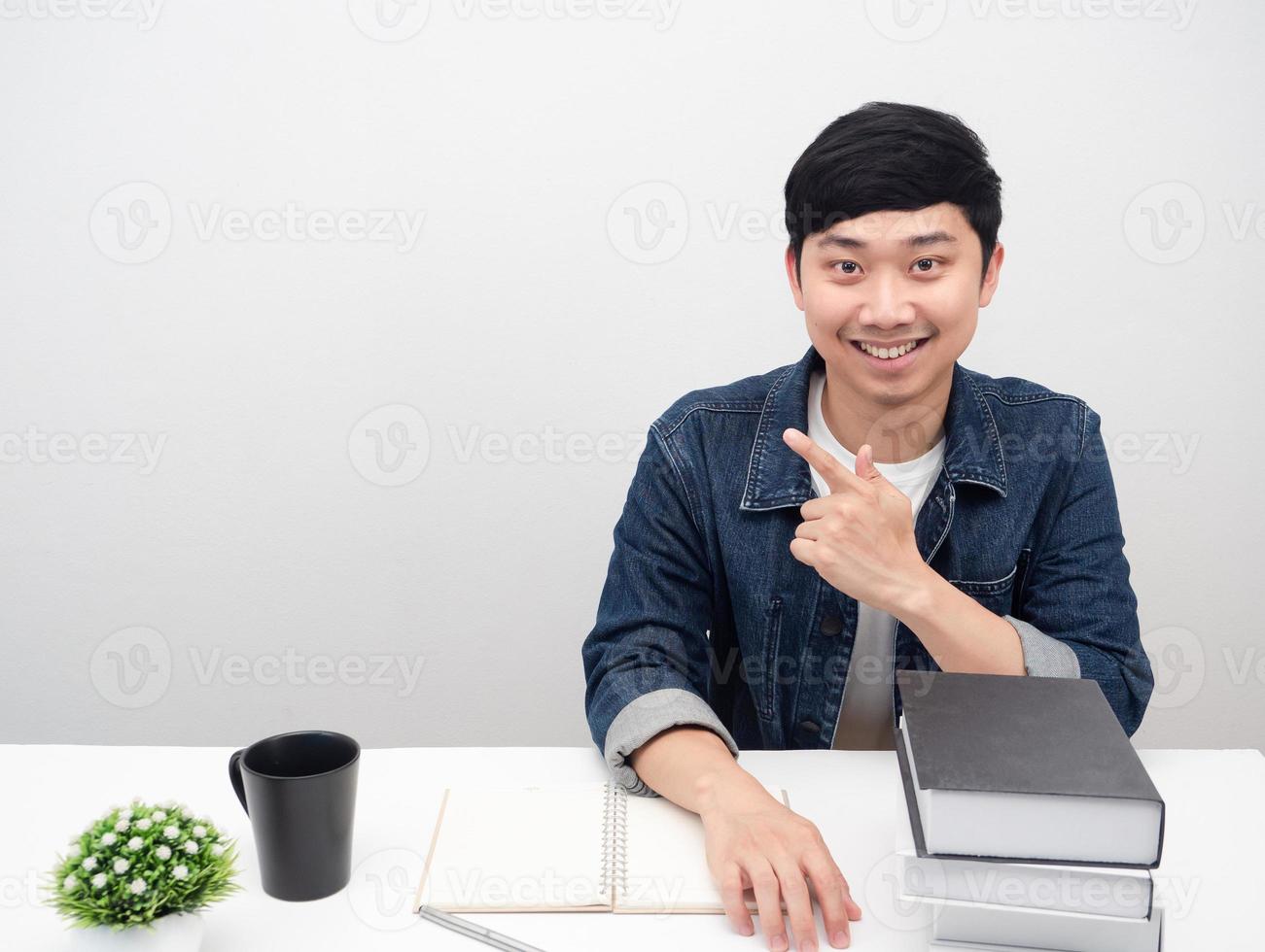 uomo d'affari sedersi a posto di lavoro Sorridi e punto dito a copia spazio foto