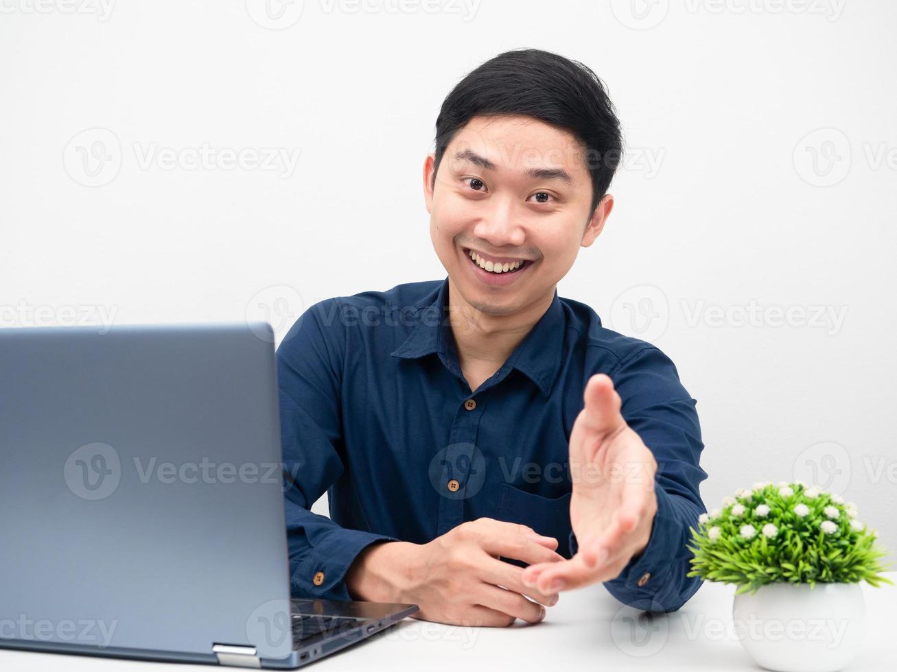 uomo seduta a posto di lavoro con il computer portatile dando il suo mano per voi allegro emozione foto