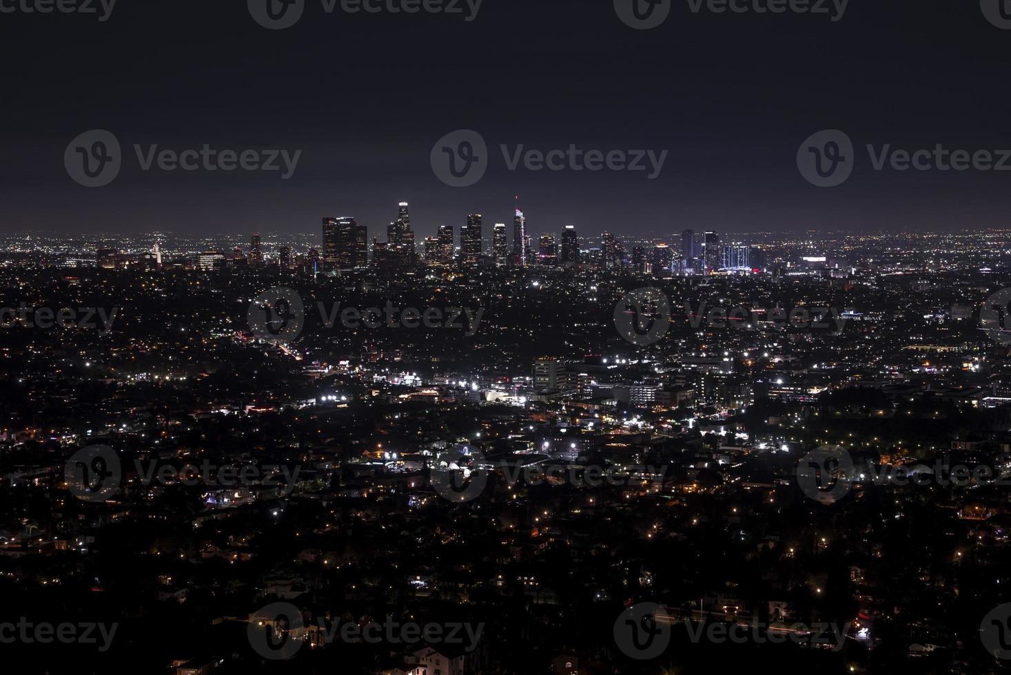 aereo Visualizza di illuminato moderno paesaggio urbano con cielo nel sfondo a notte foto