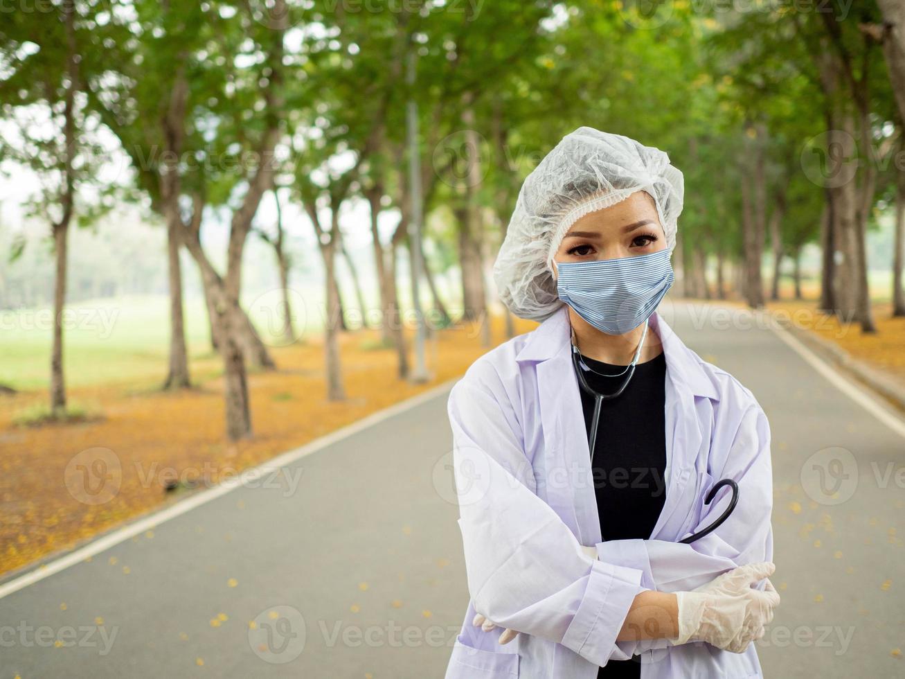 femmina donna signora infermiera medico uniforme stetoscopio all'aperto giardino naturale ambiente ricerca laboratorio chimica scienza medico farmacia braccio attraversare ritratto opera lavoro occupazione vaccino copia spazio foto