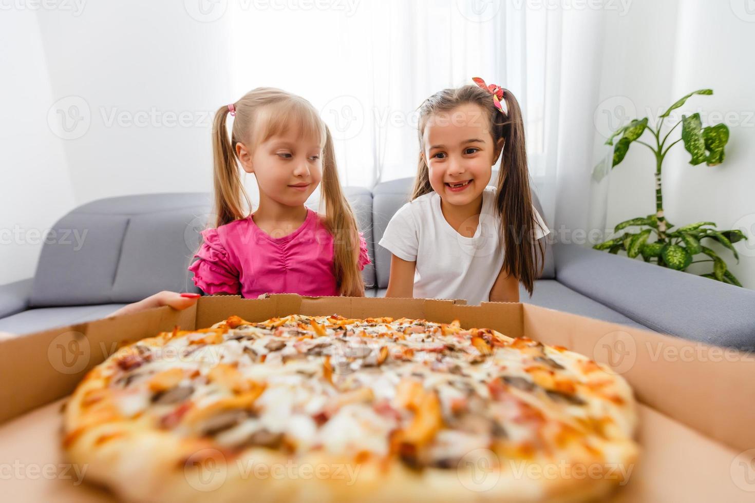 ritratto di carino poco ragazza seduta e mangiare Pizza foto