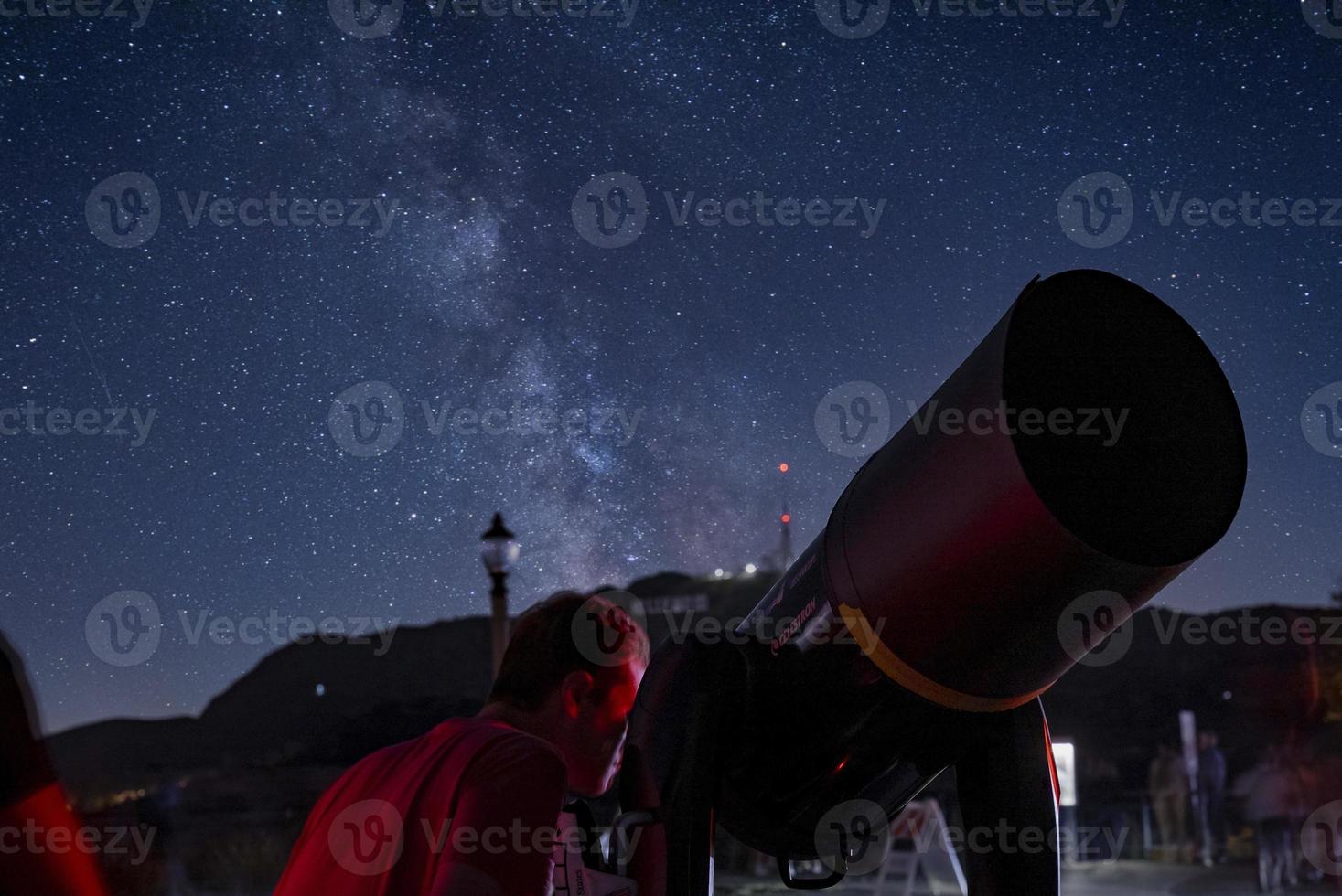 uomo guardare attraverso telescopio a griffith osservatorio di montare hollywood foto