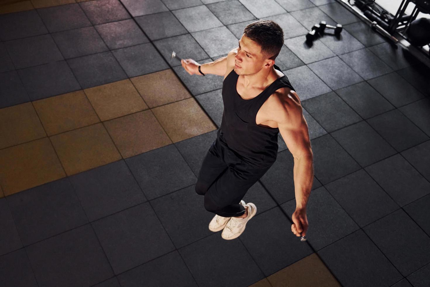 forte uomo nel allegro Abiti avere allenarsi giorno nel il Palestra di utilizzando salto corda foto