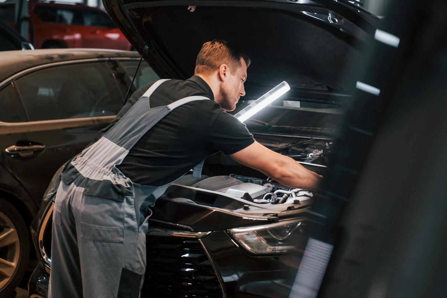 con illuminazione attrezzatura. uomo nel uniforme è Lavorando nel il auto servizio foto