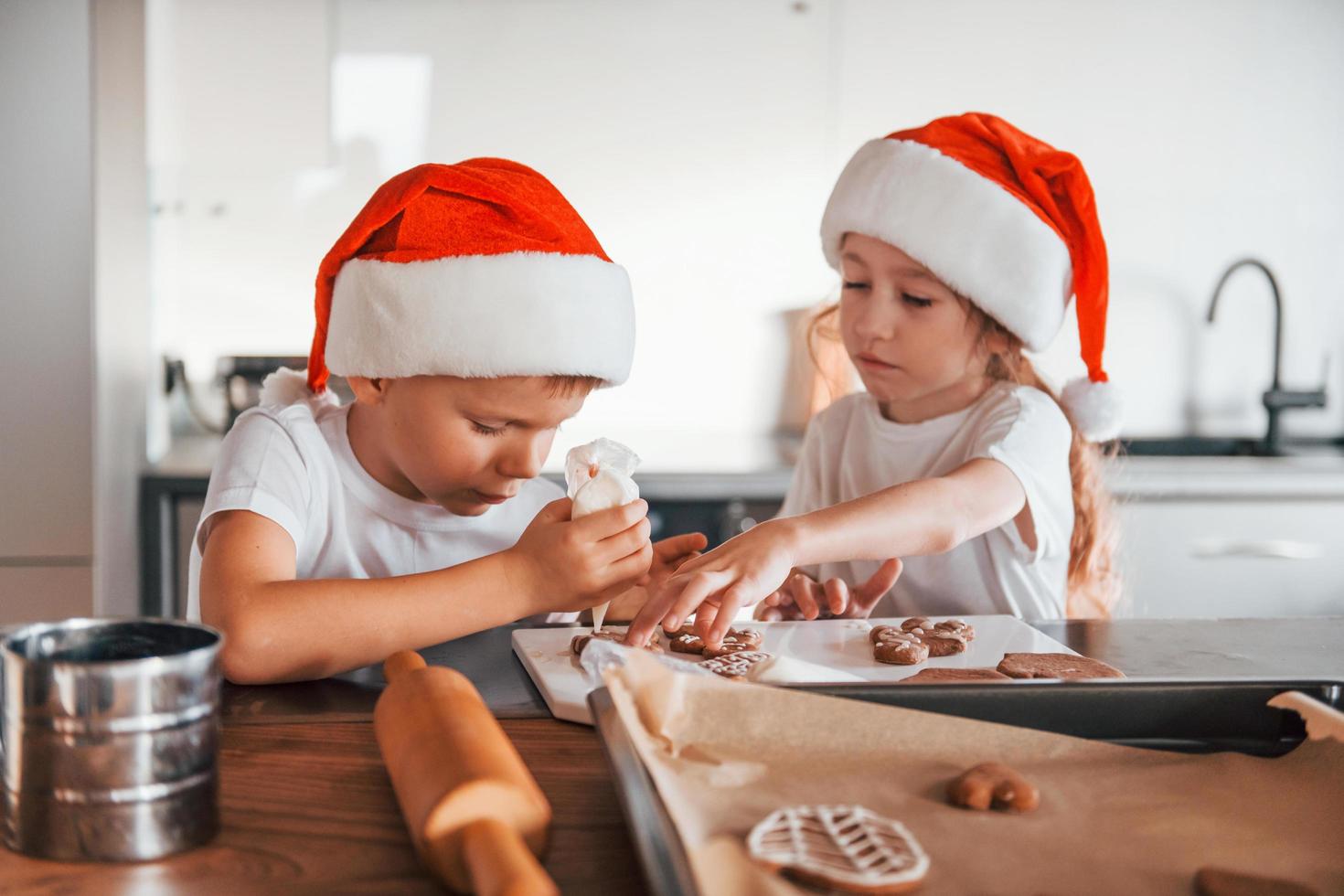 nuovo anno anticipazione. poco ragazzo e ragazza preparazione Natale biscotti su il cucina foto