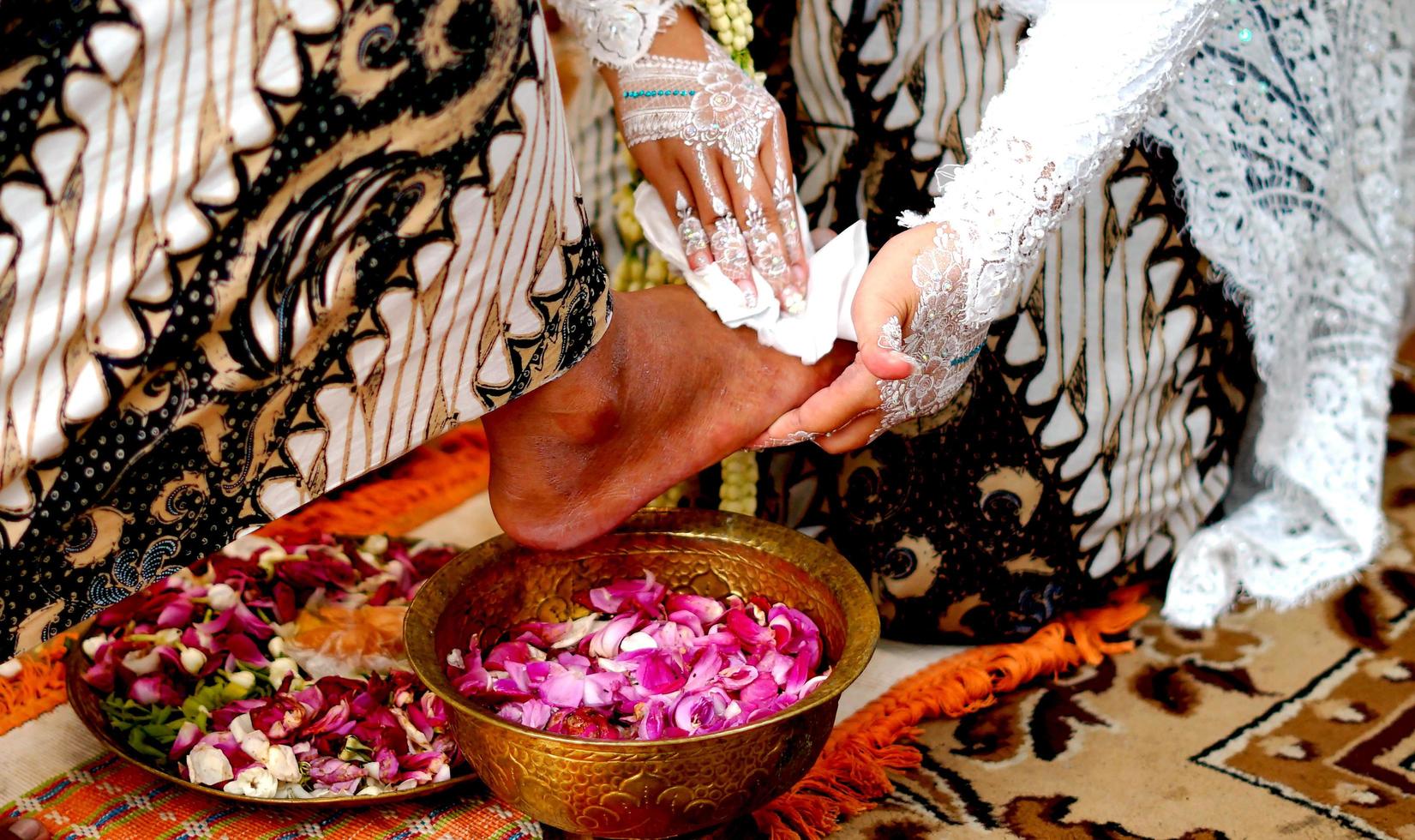 nozze tradizione nel Indonesia il sposa lavaggi il quello dello sposo piedi foto