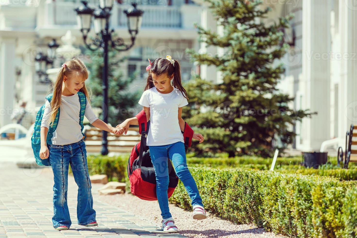 Due studentesse partire per scuola. il concetto di scuola, studia, formazione scolastica, amicizia, infanzia. foto