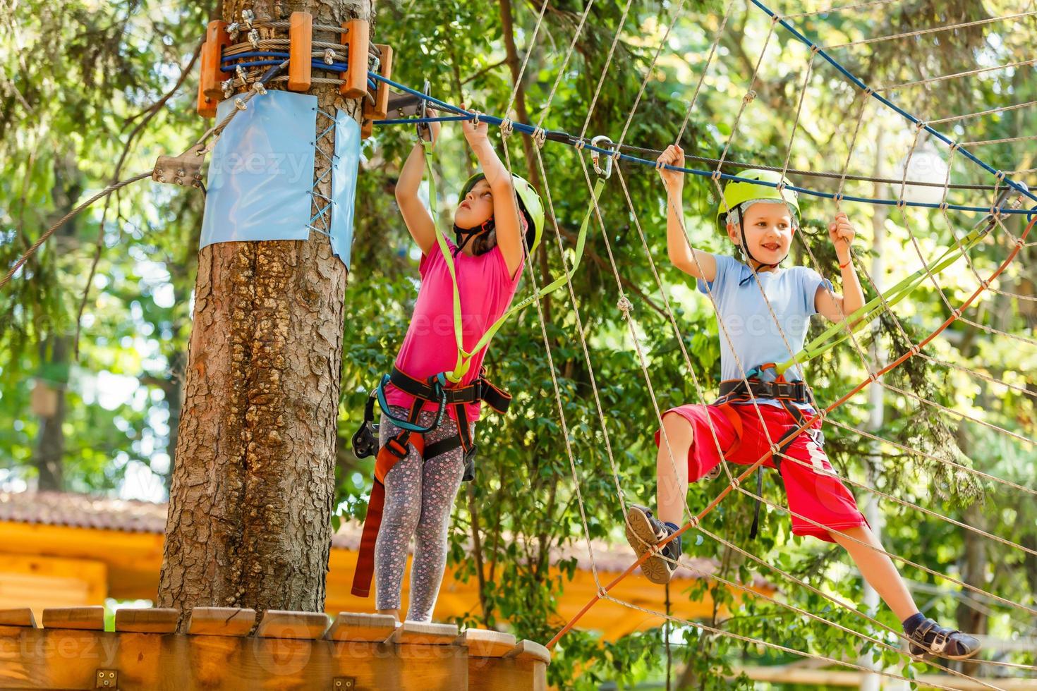 avventura arrampicata alto filo parco - bambini su corso corda parco nel montagna casco e sicurezza attrezzatura foto