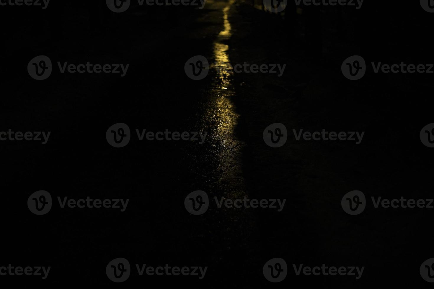 linea di leggero nel scuro. traccia a notte. bagliore su bagnato strada. foto