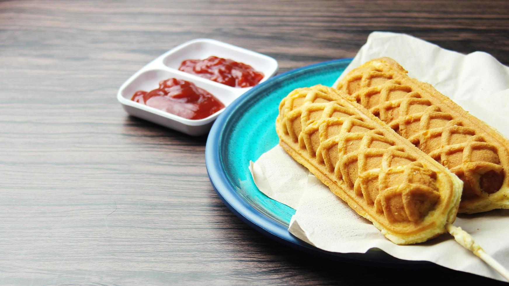 cialda bastoni Mais cani caldo cane cialde su un' bastone ketchup su un' di legno tavolo foto