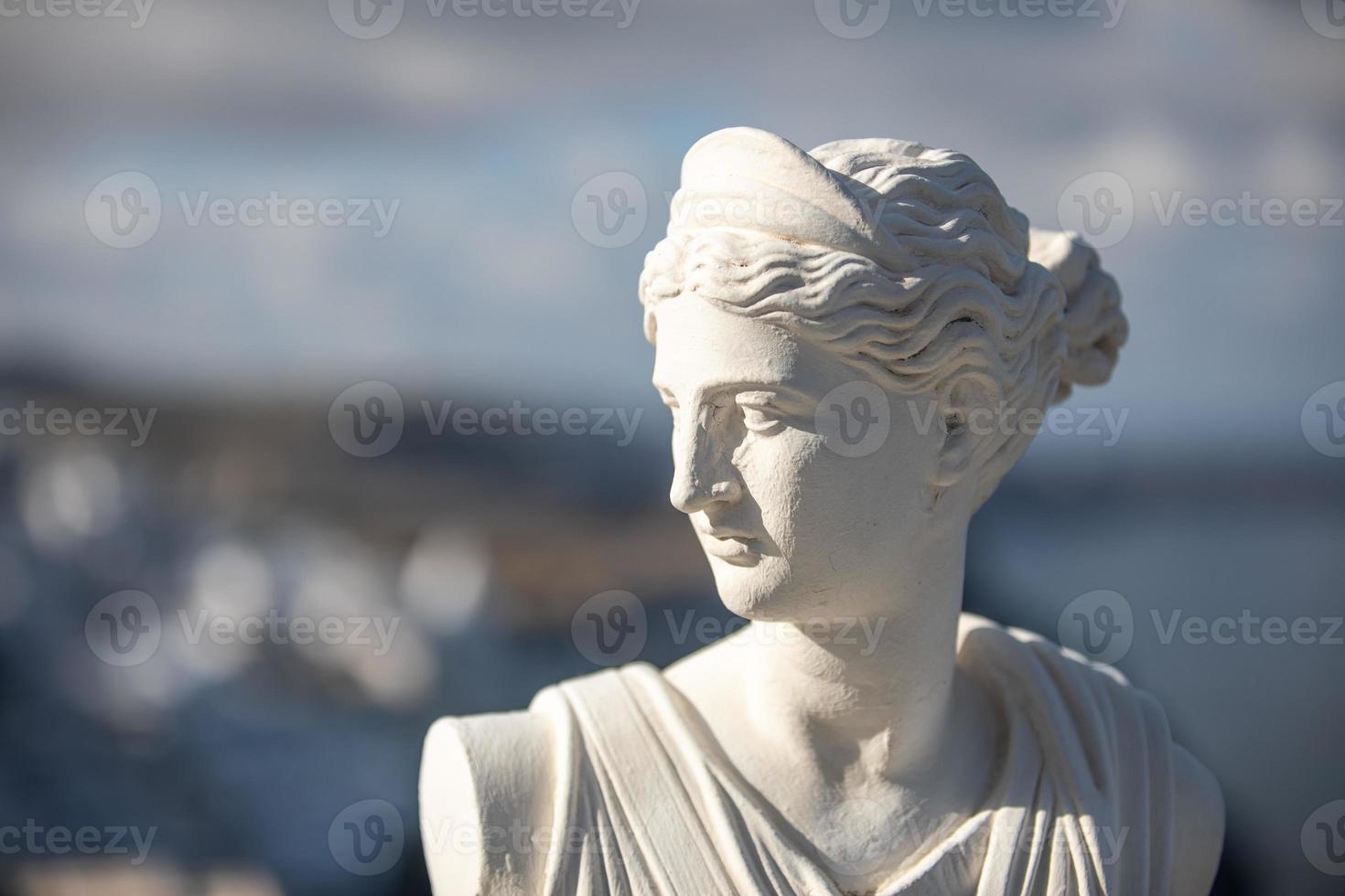 bianca statua di artemide, Diana dea con sfocato santorini fira Visualizza nel Grecia. storico ritratto e tradizionale arte nel Grecia foto