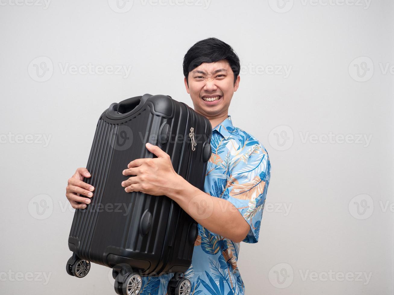 giovane uomo spiaggia camicia gesto trasportare pesante lagage viaggio a vacanza isolato foto