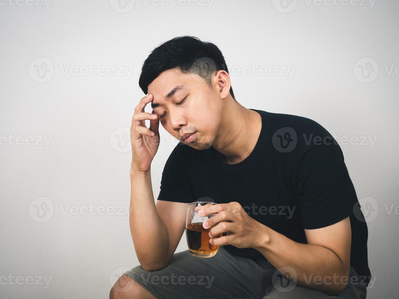 giovane uomo sedersi si sente sforzo hold alcool nel mano bianca sfondo foto