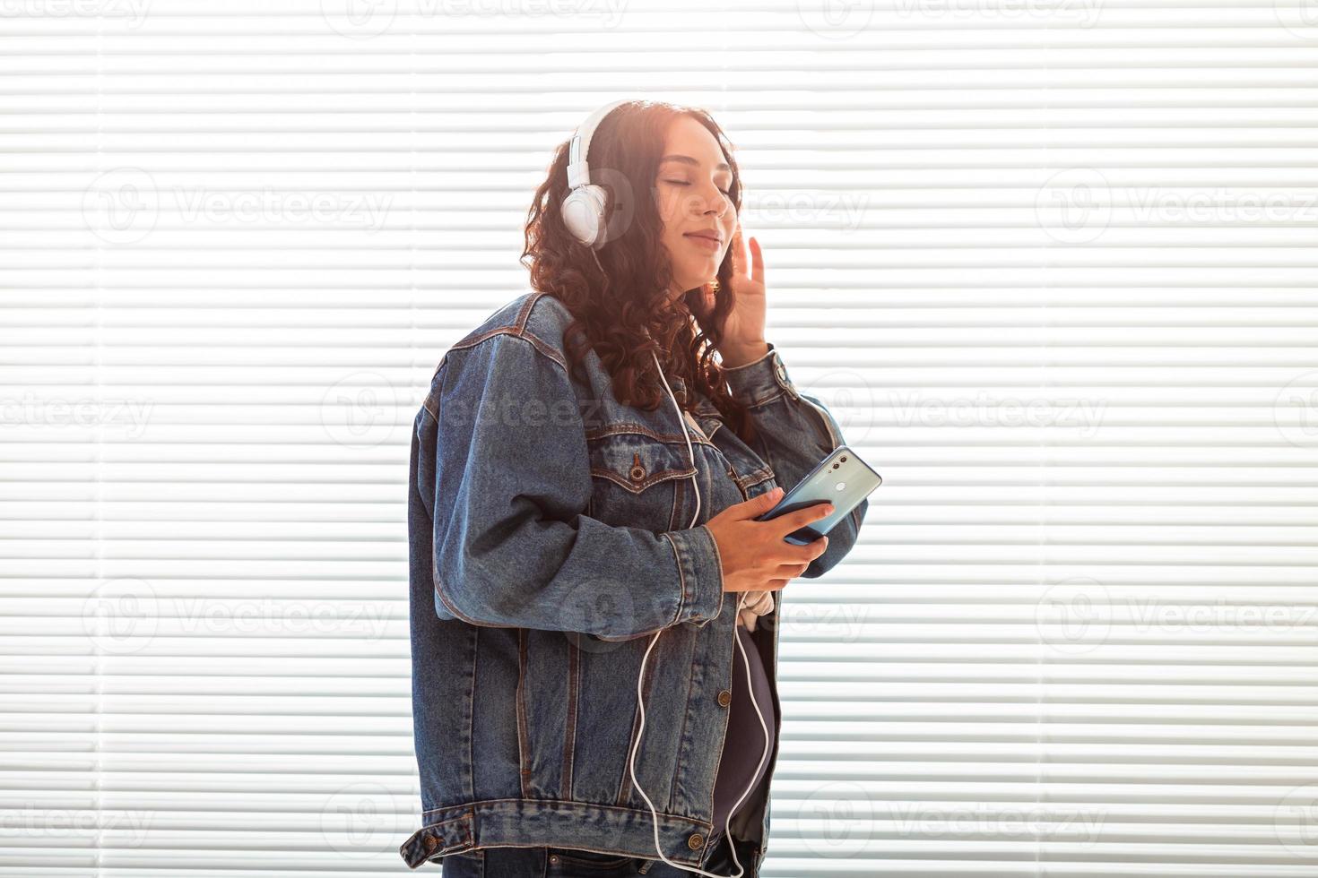 bellissimo giovane tranquillo, calmo incinta donna ascolta per piacevole classico musica utilizzando smartphone e cuffia. concetto di positivo atteggiamento prima parto. copia spazio foto