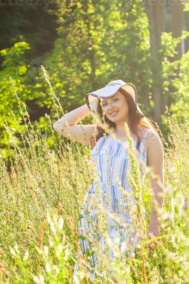 donna a piedi nel un' campo nel estate soleggiato giorno. foto